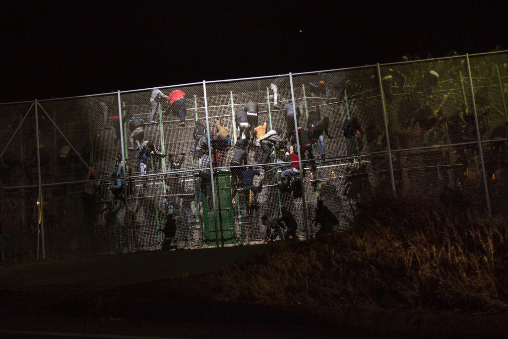Immigrants salten la triple tanca metàl·lica que separa Nador (Marroc) i Melilla. Foto: Santi Palacios