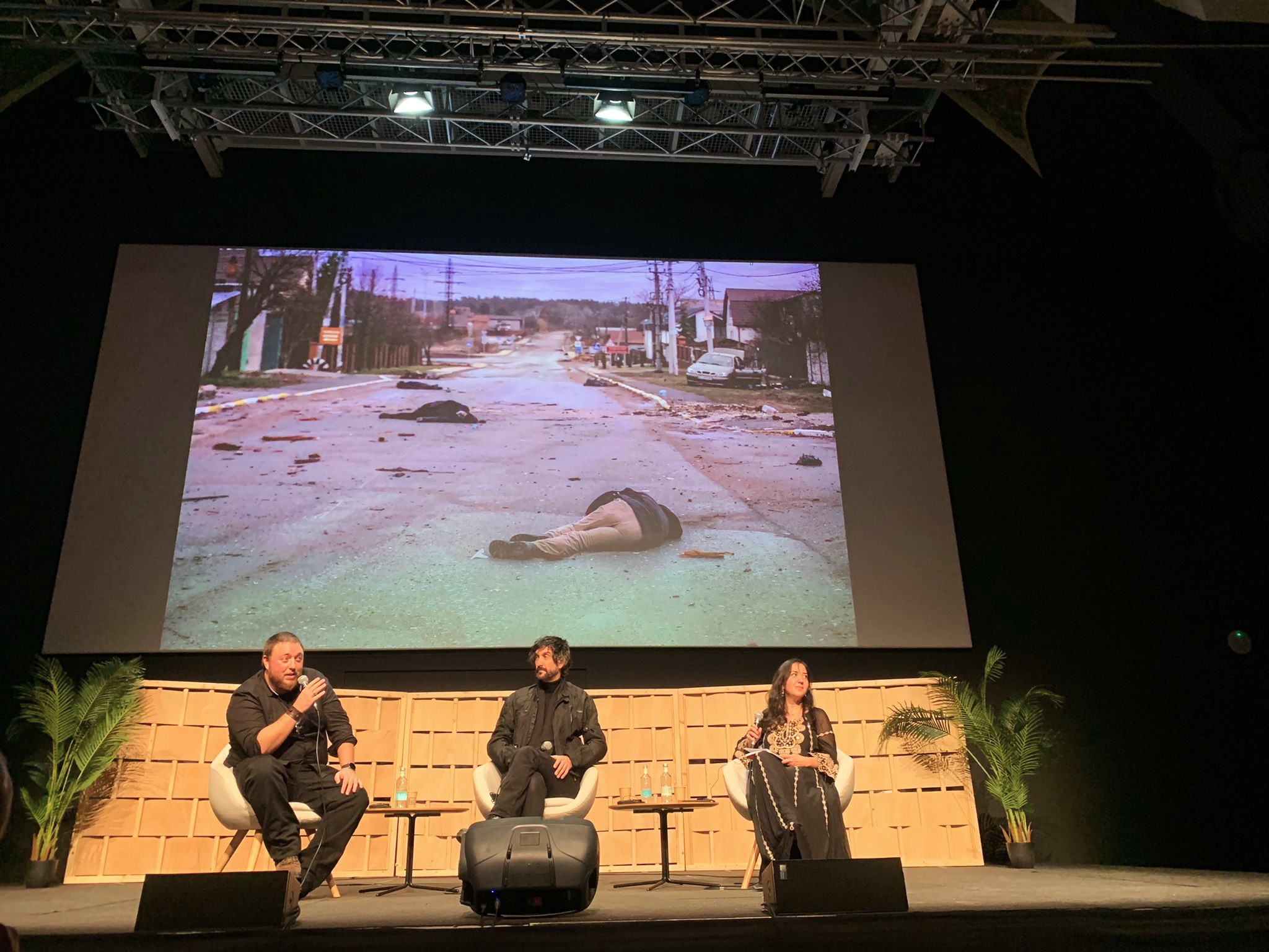 Un moment de la xerrada amb una fotografia, al darrere dels ponents, de Bucha feta per Palacios. Foto: Laia Micó